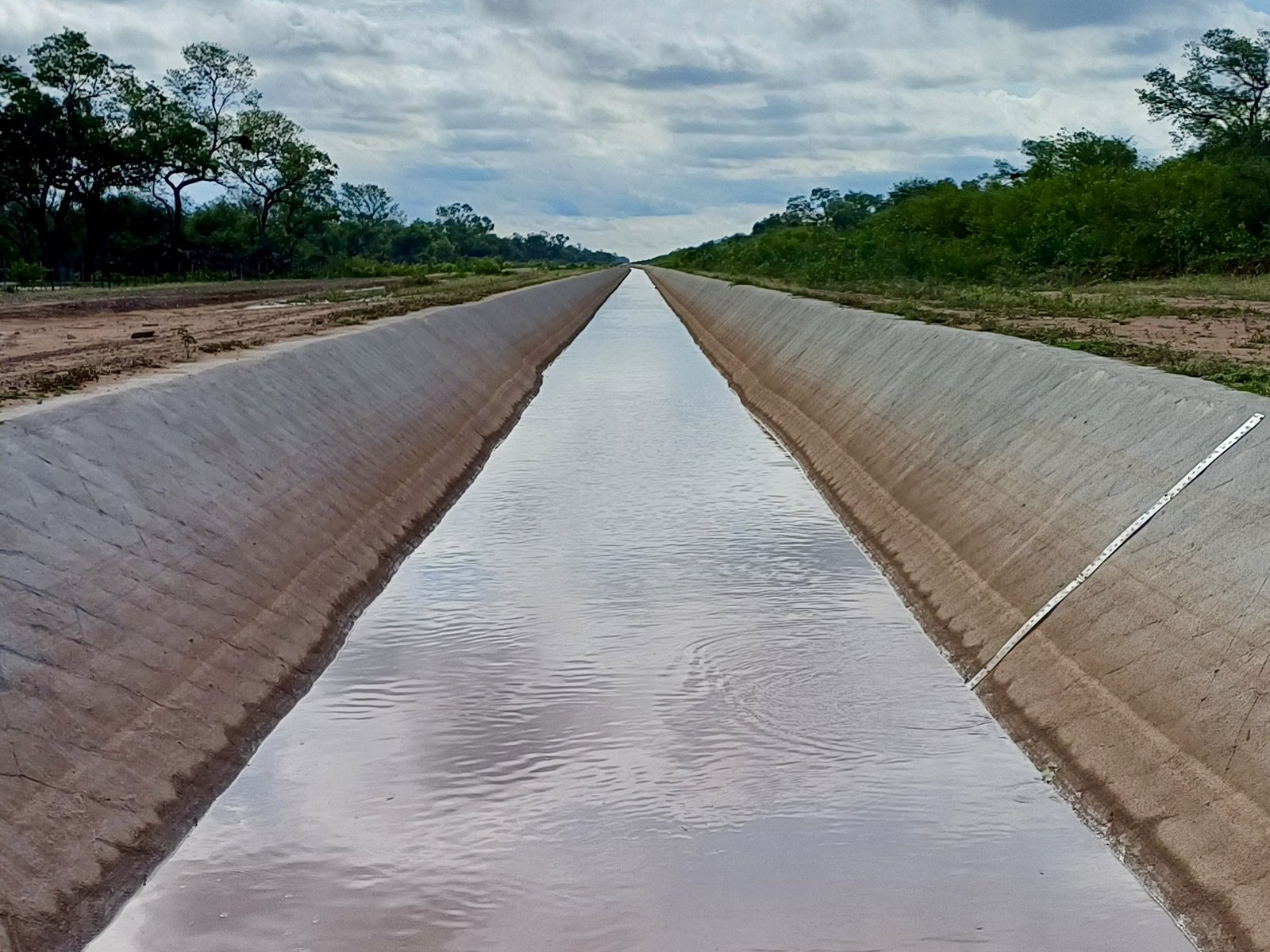 The concrete canal seen from inside, running straight to the horizon